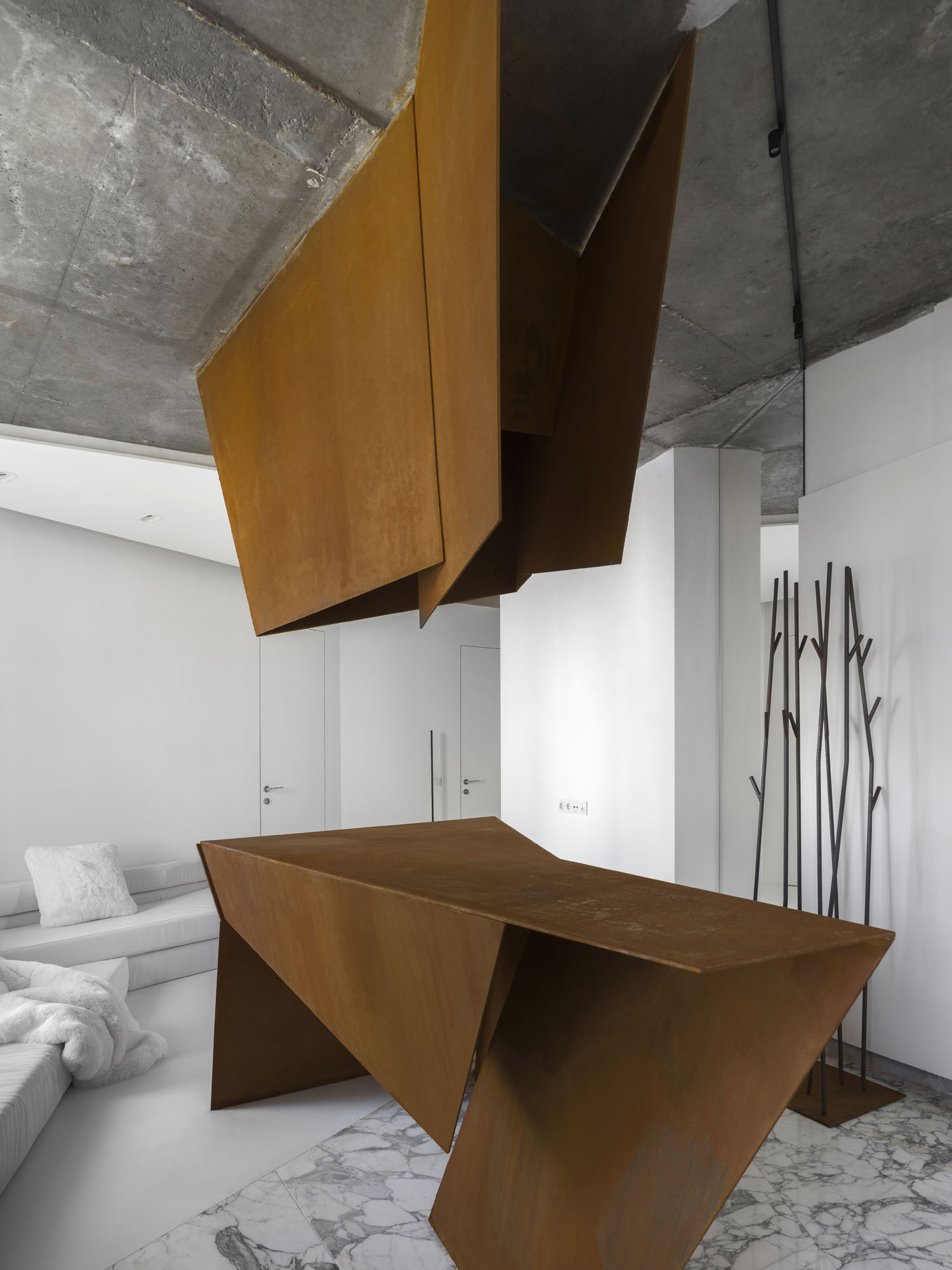 a large sculptural object suspended from the ceiling and rising up from the floor inside an apartment