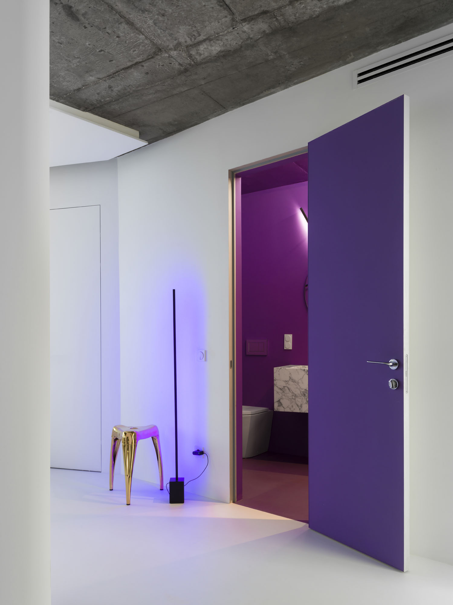 an open door to a purple room from a white room
