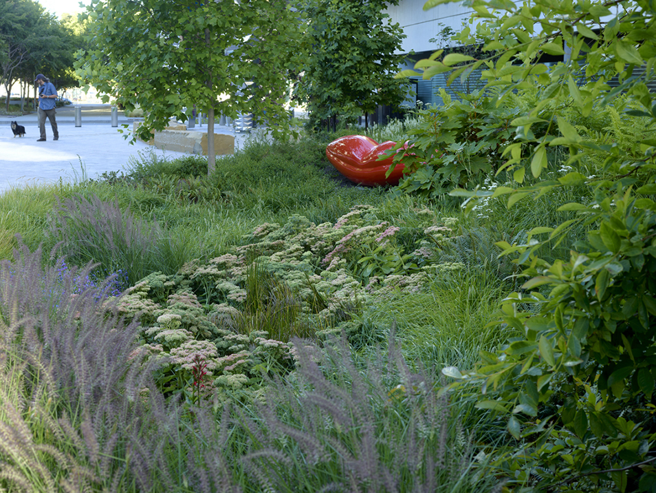 plants in foreground, lips sculpture in background