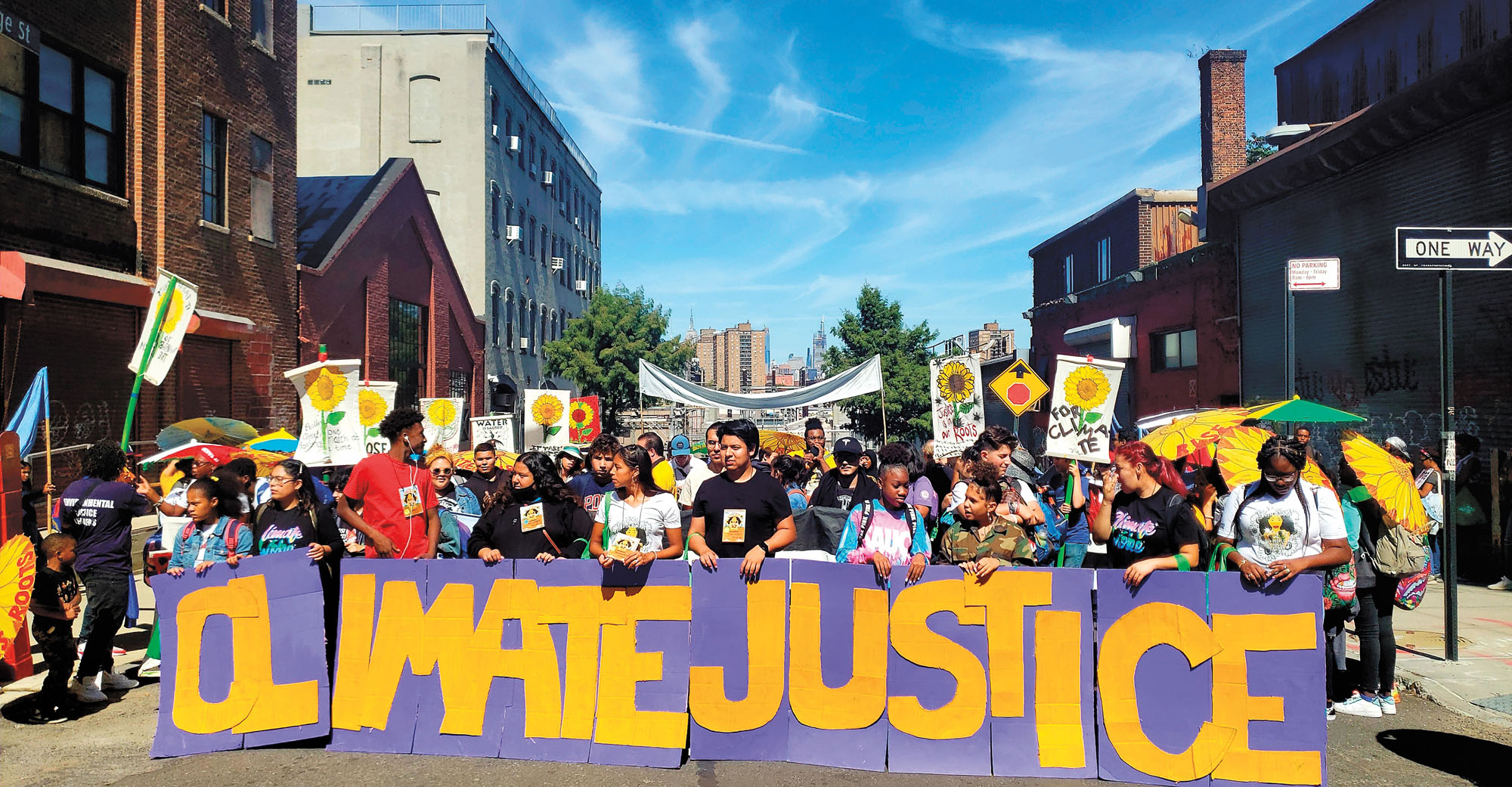 Climate justice protesters carrying a sign that reads "Climate Justice"