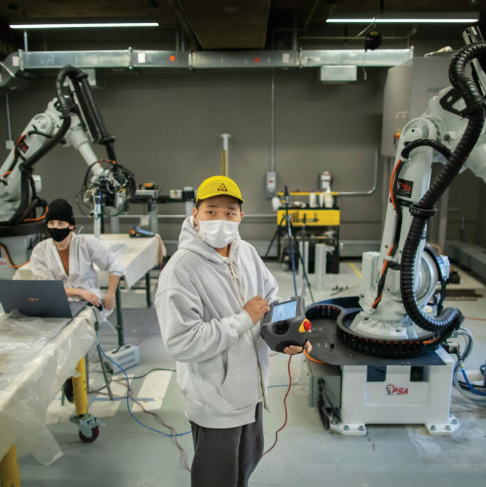 man standing in front of a robotic arm