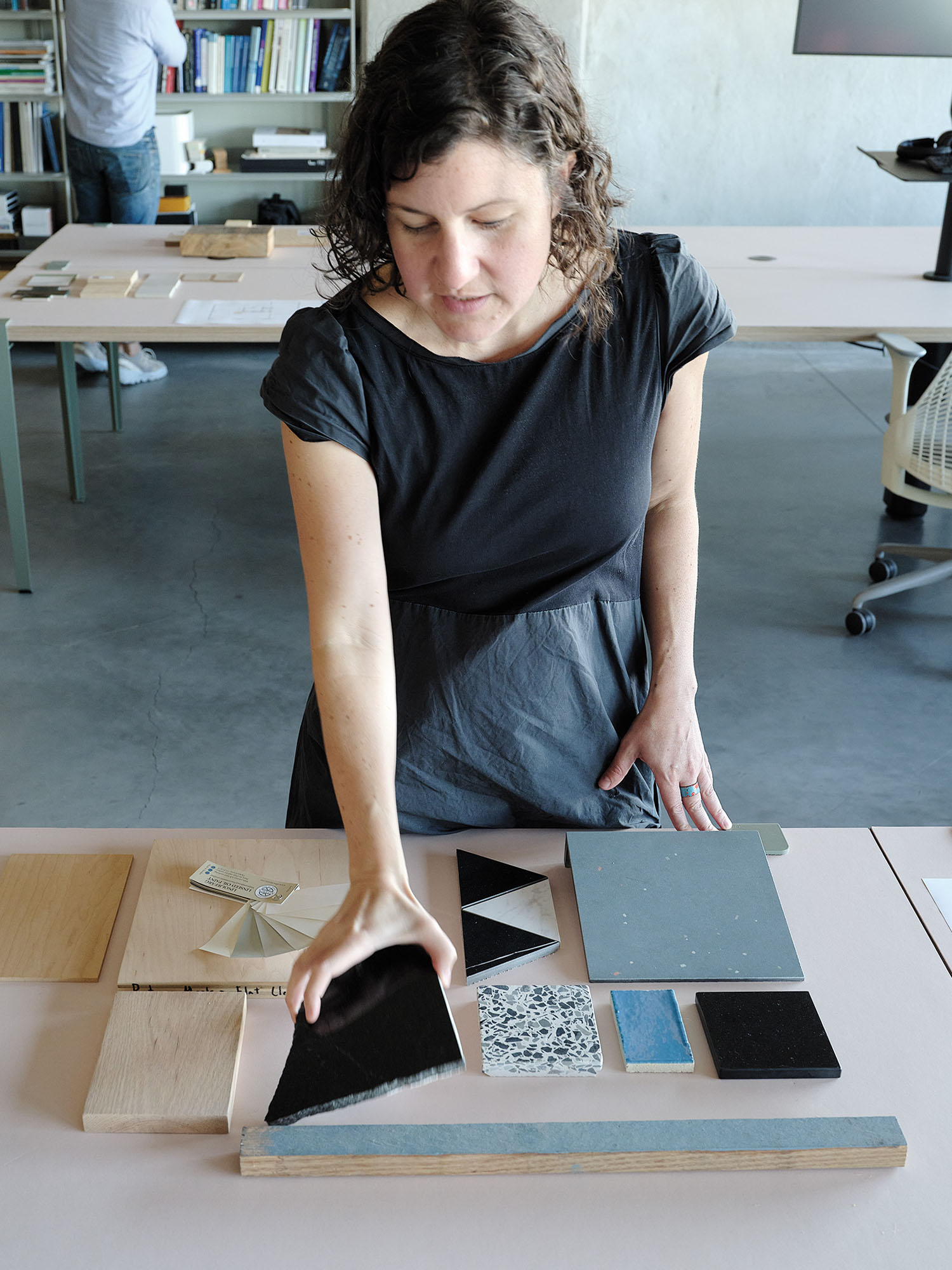 A photograph of an architect inspecting tile samples