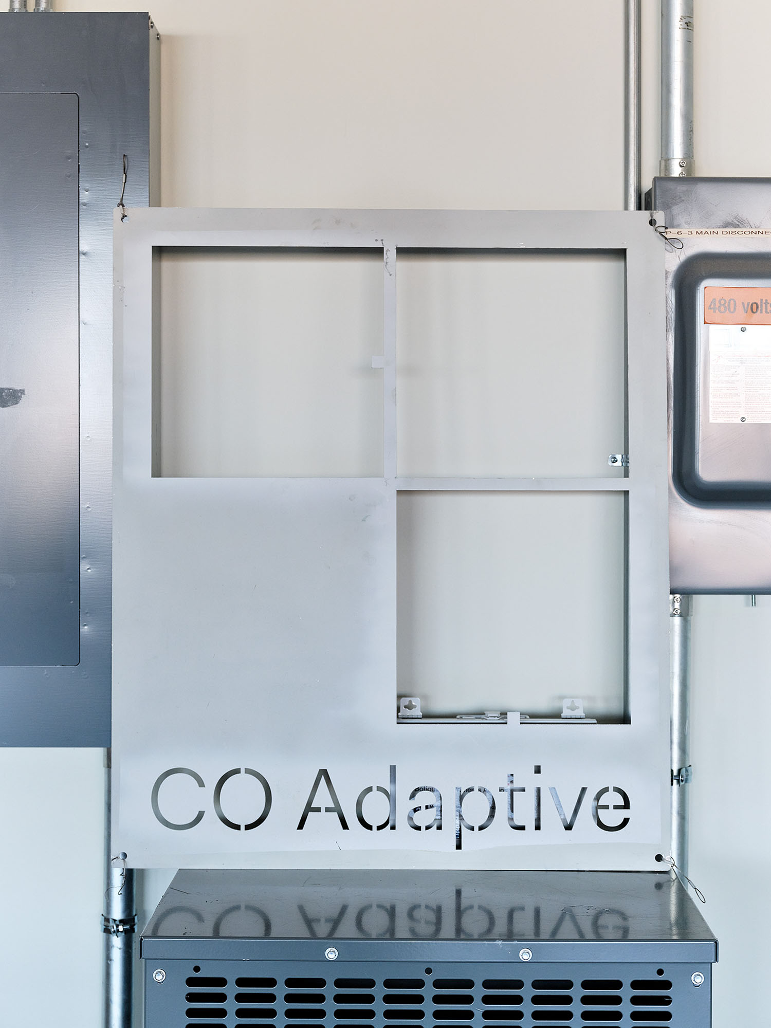 a photograph of a metal panel with the words CO Adaptive on it