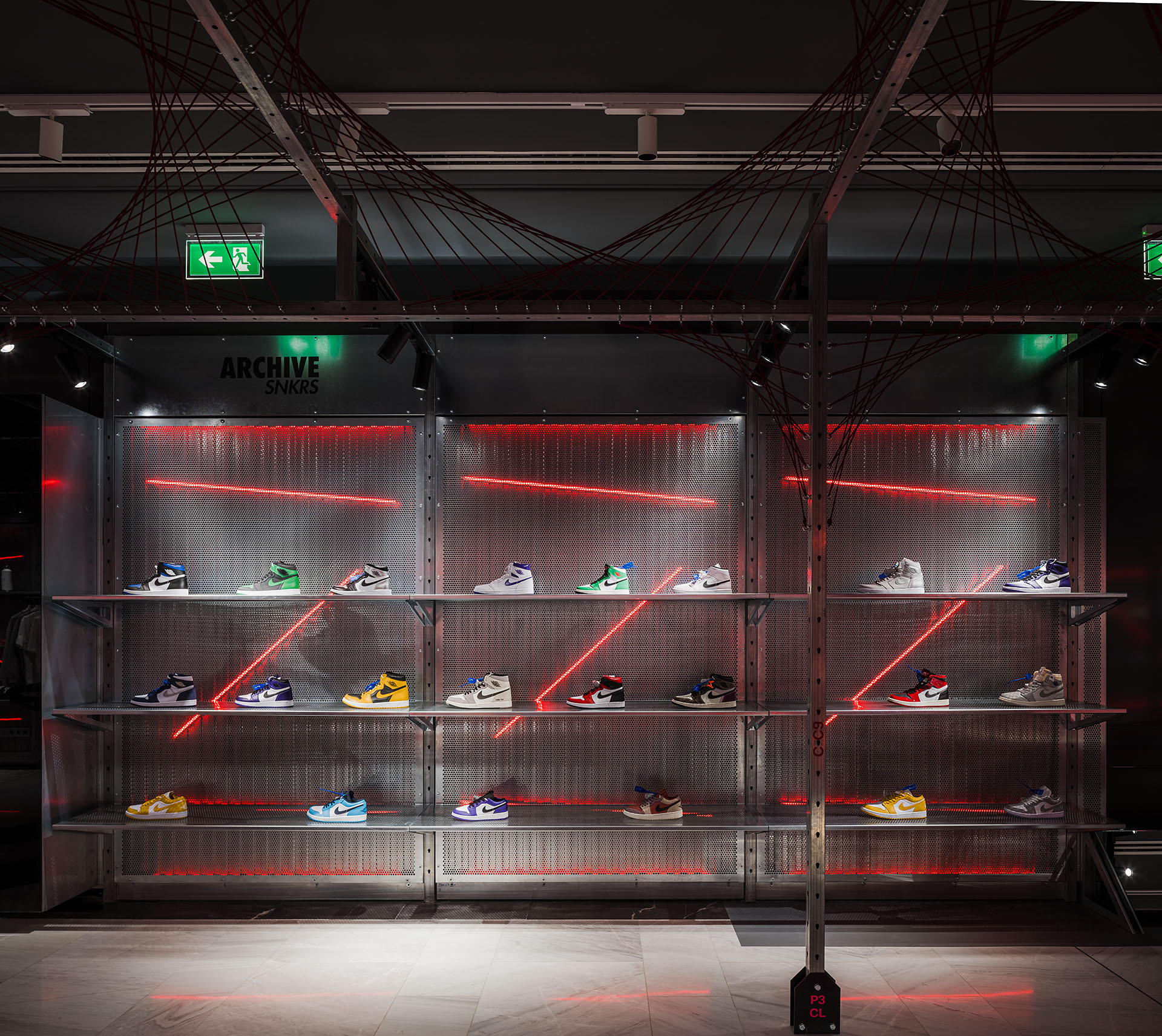 sneakers on display on a shelf with lighting behind it