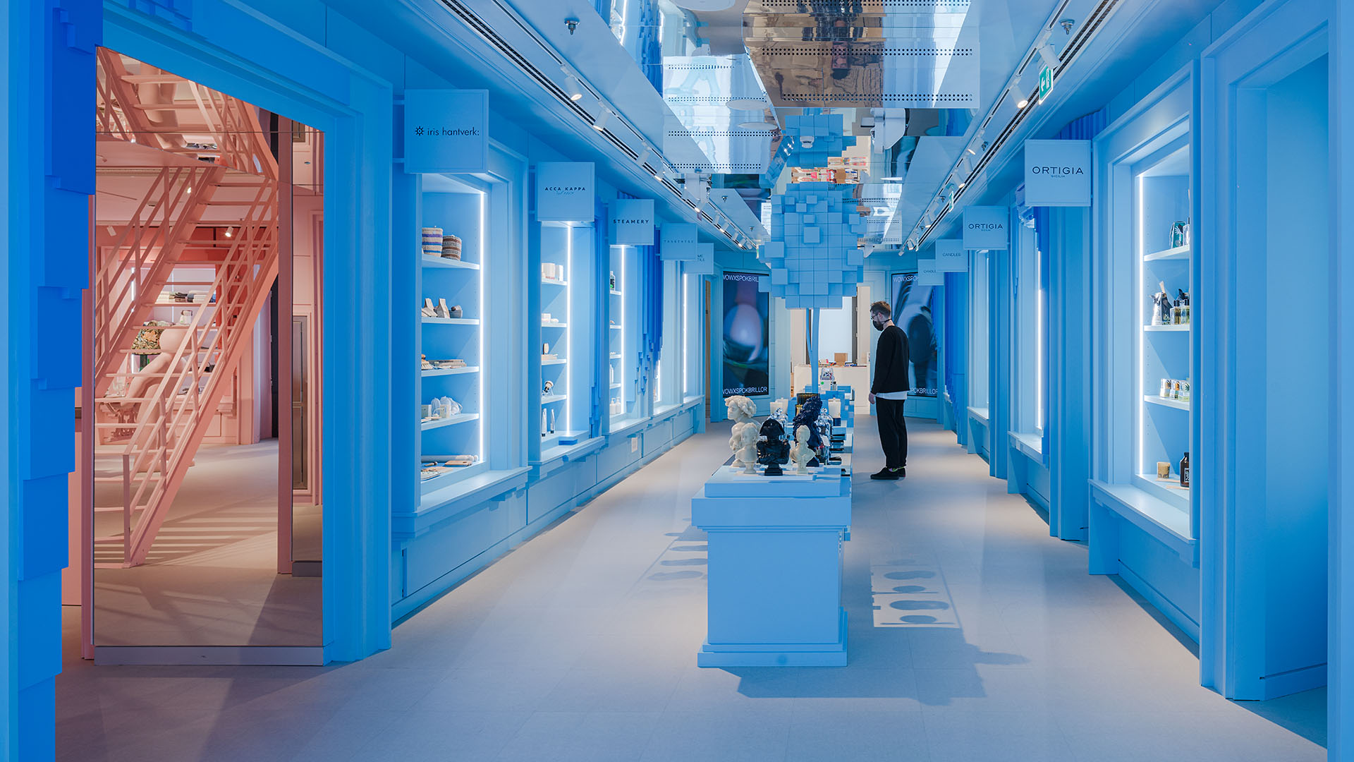blue-walled retail space where a shopper is looking at products