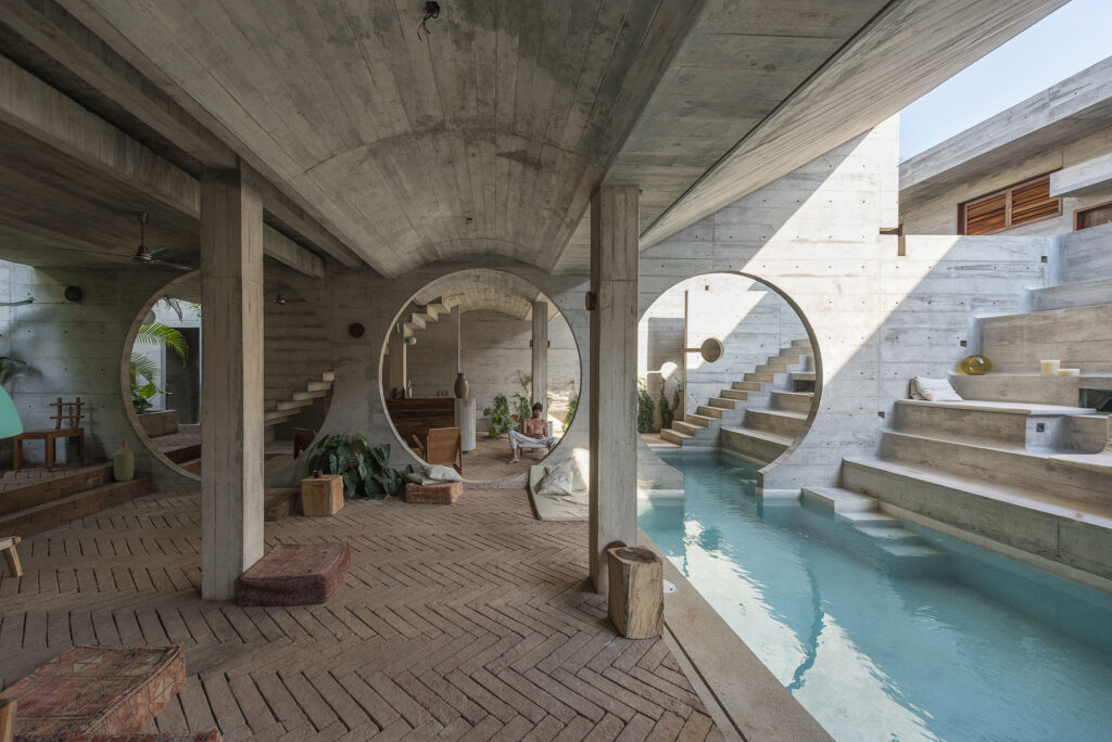 an image of an open air lounge area and infinity pool made with concrete and brick