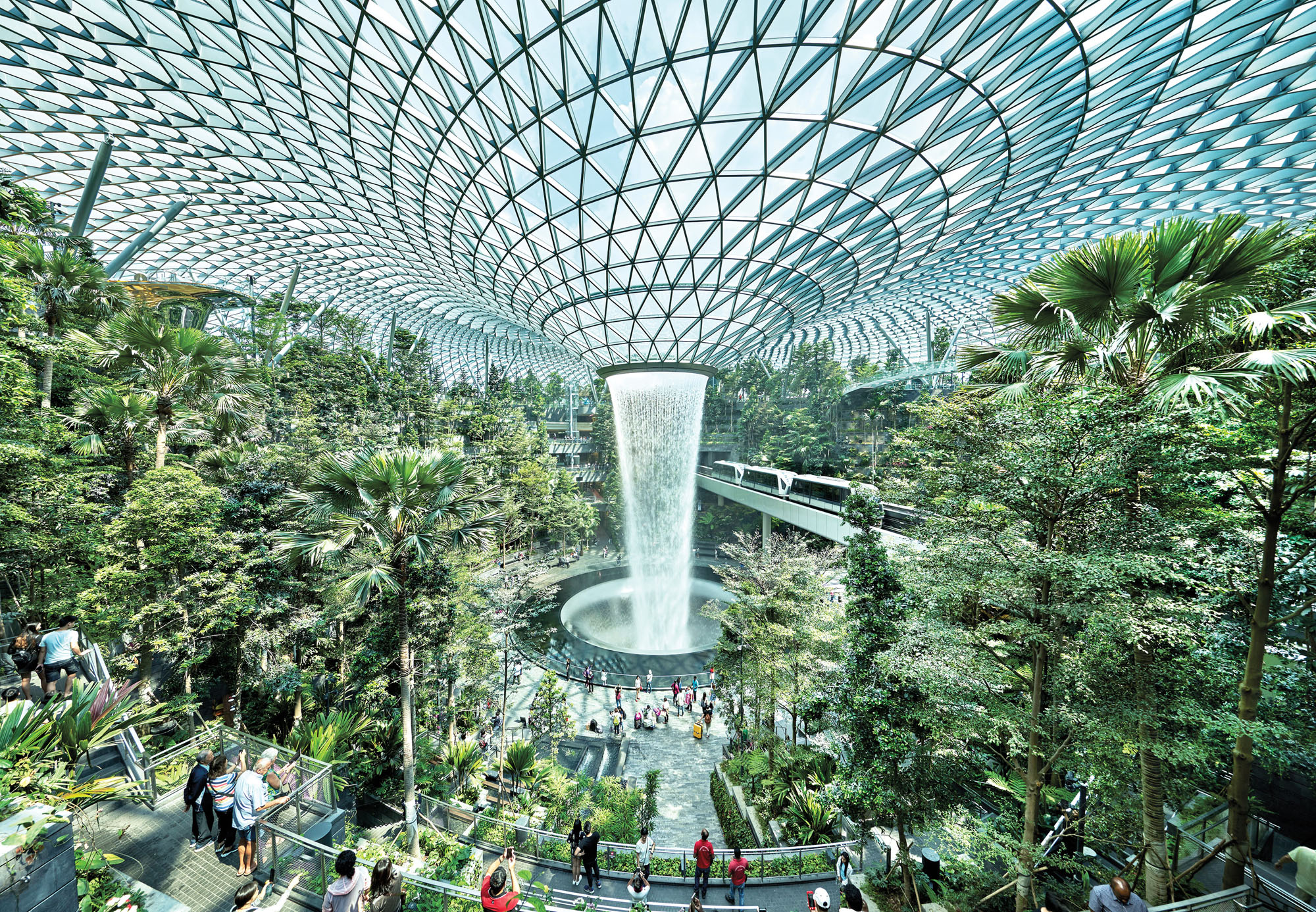 A photograph of the Jewel Changi Airport in singapore with a central waterfall and lush plantings all around