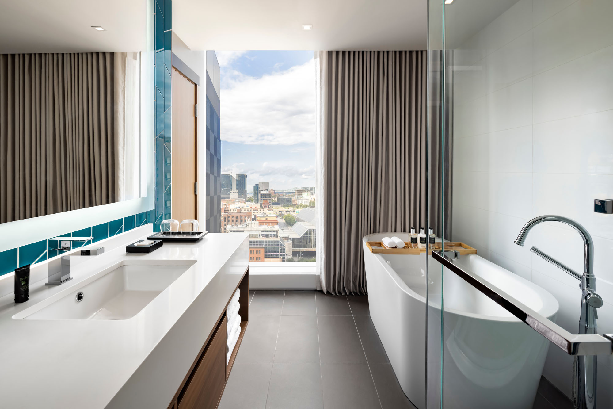 interior of a bathroom in a high rise condo with a window that looks out to montreal