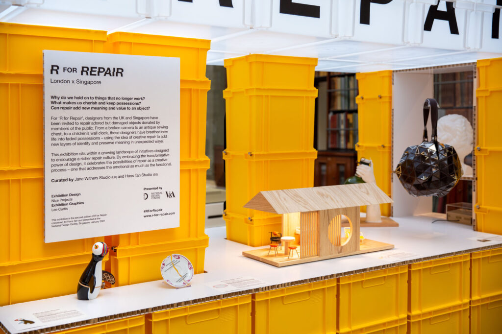 An installation view of an exhibition featuring a display made of yellow plastic bins