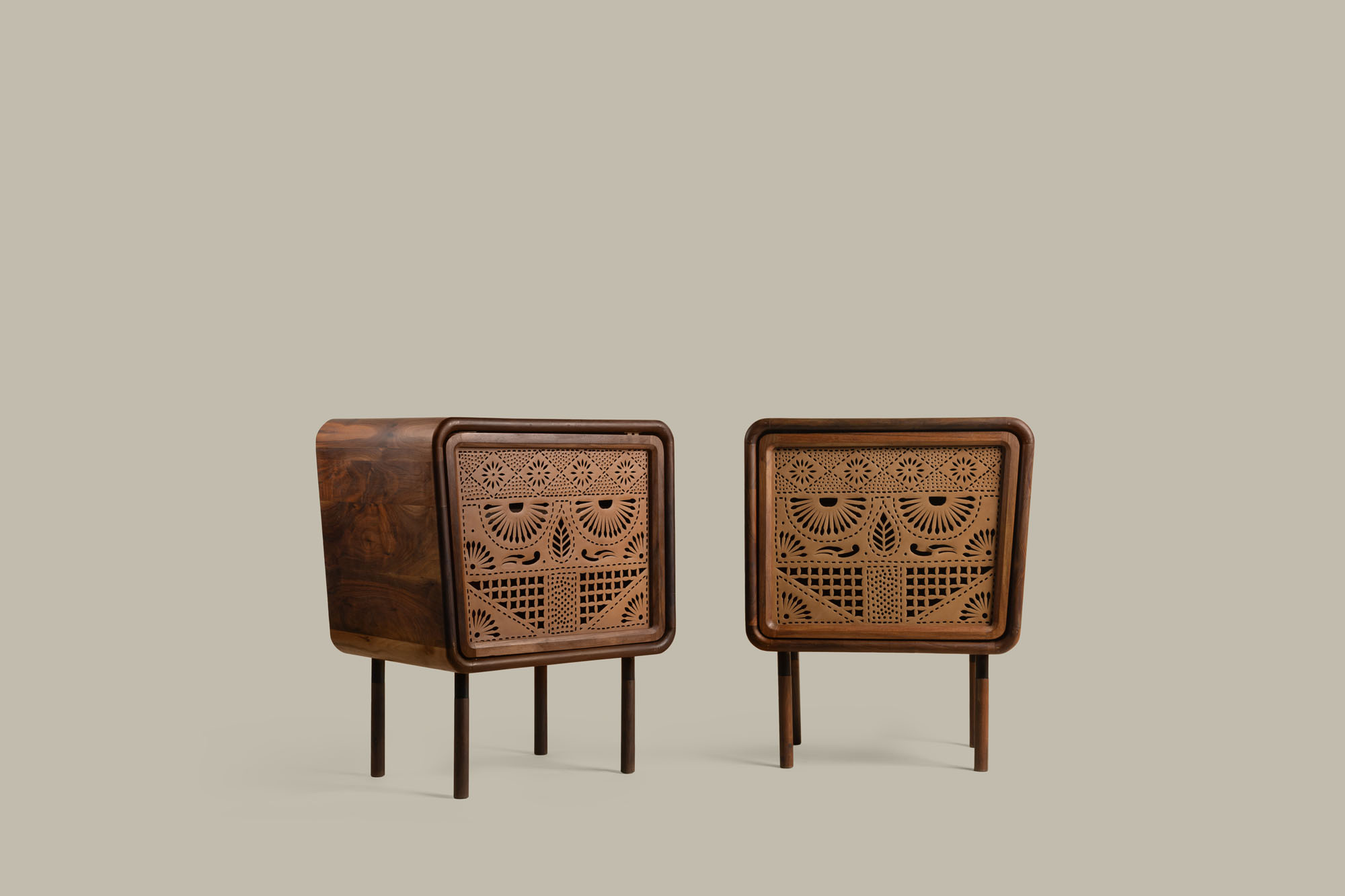 two carved wooden tables against a beige background