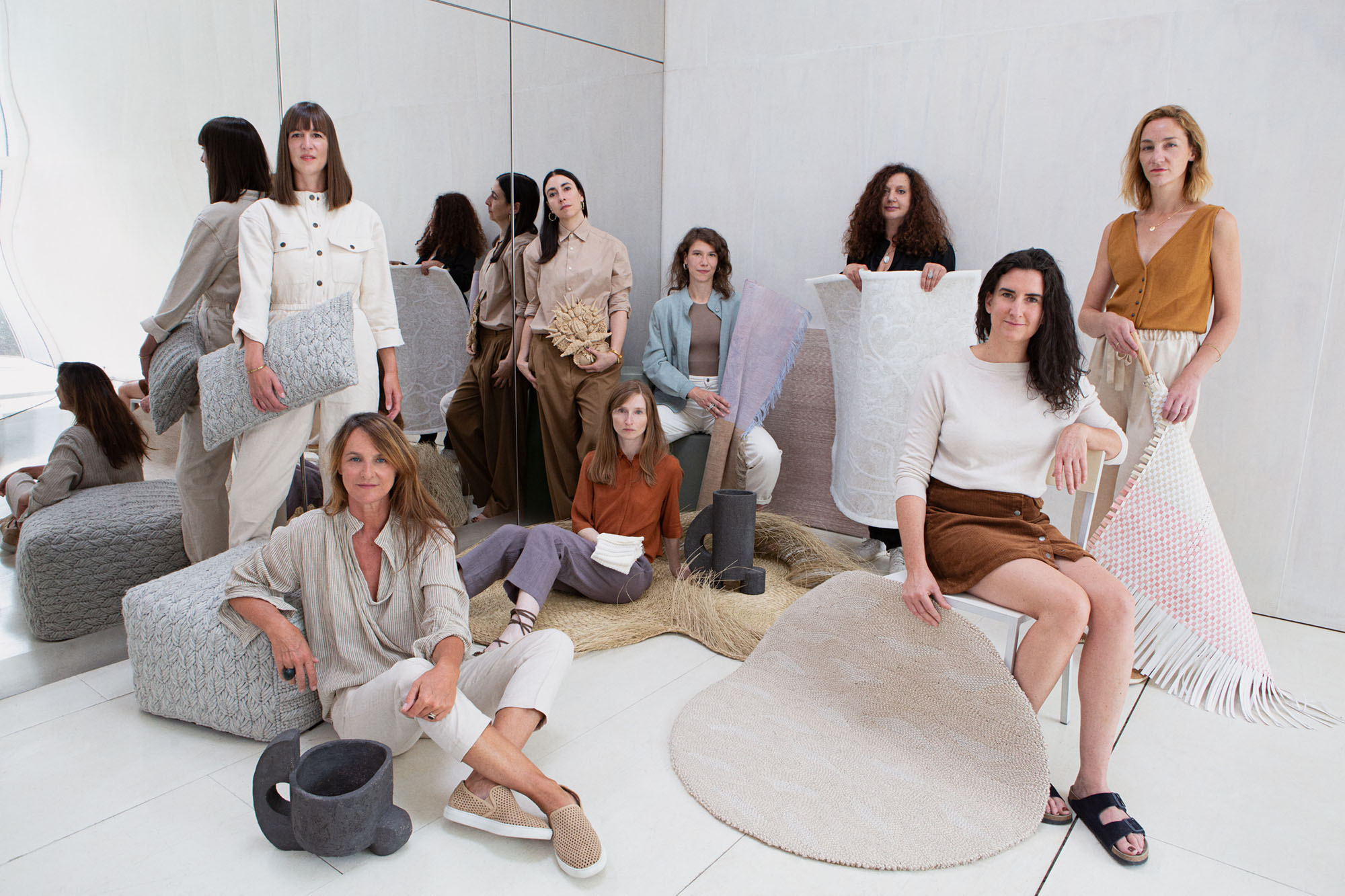 group of designers seated and standing holding their creations
