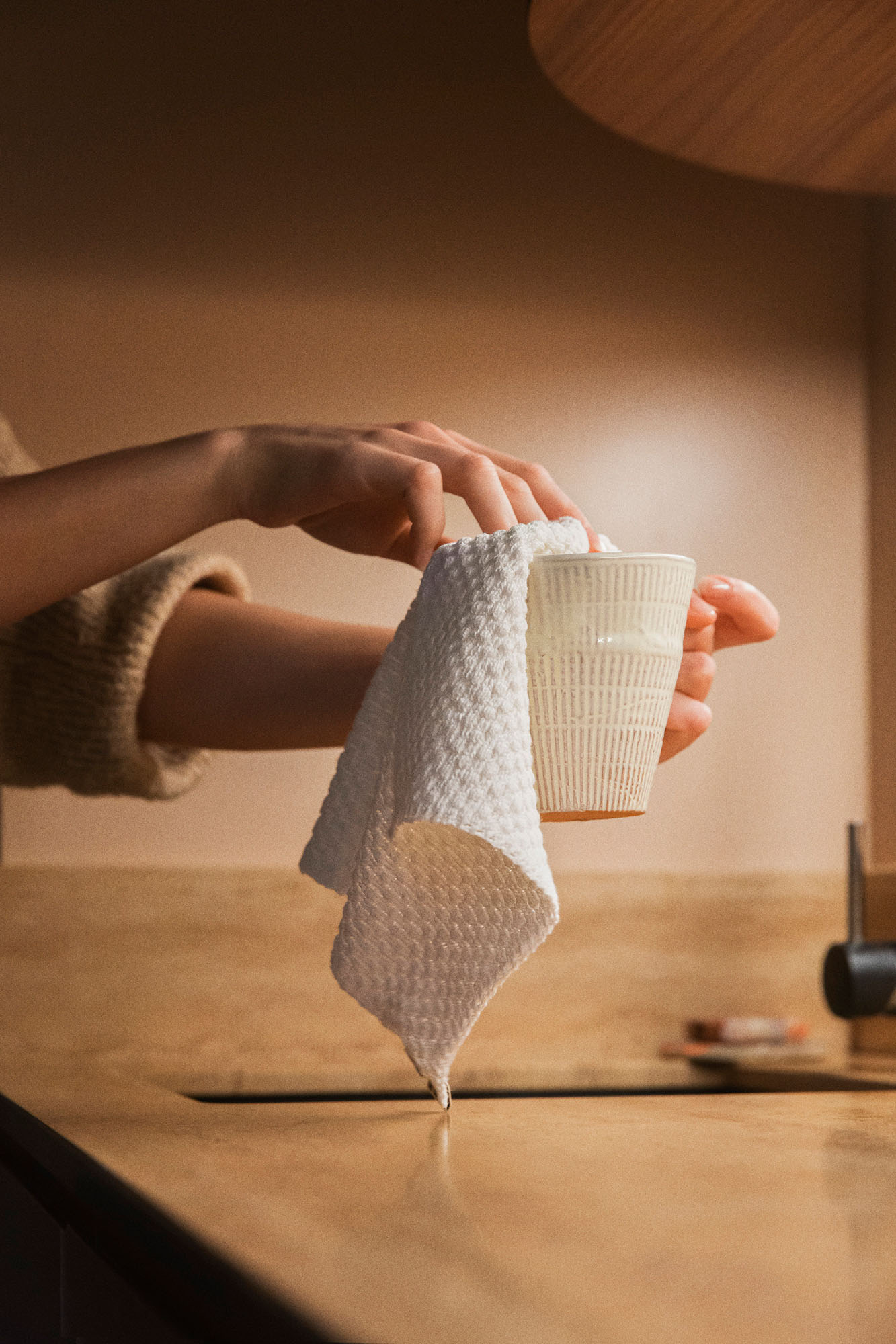person using cloth to clean cup
