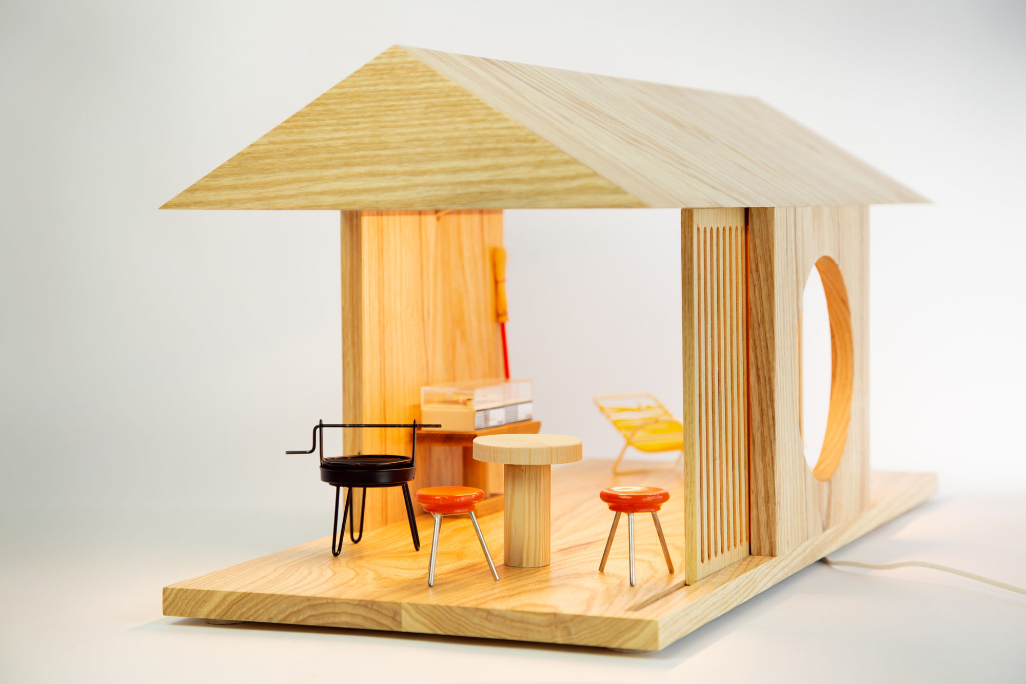 an image of a modern doll house made of wood with miniature furniture pieces in it. 