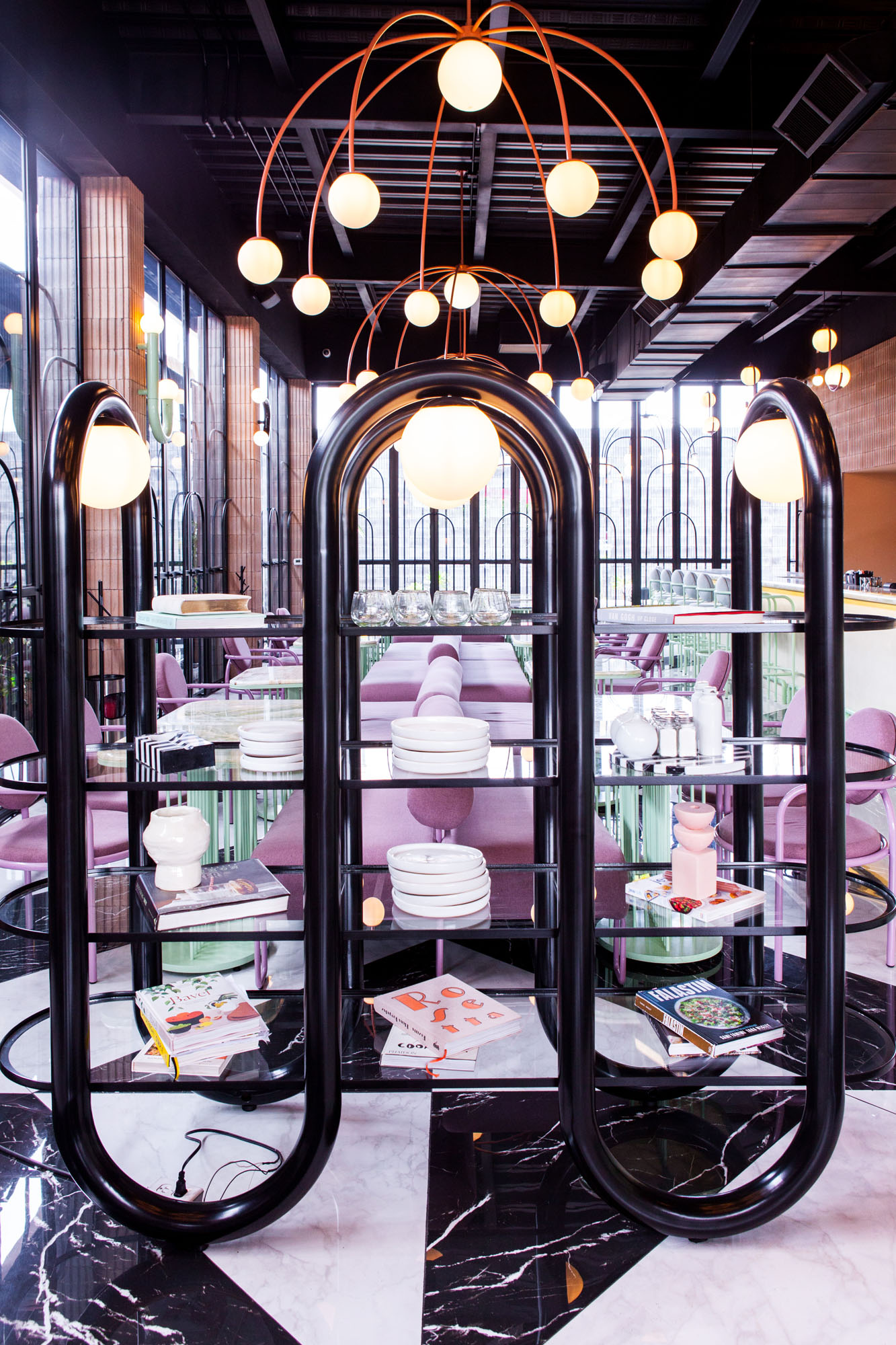 interior of a restaurant showing pastel colored tables and a large black shelf