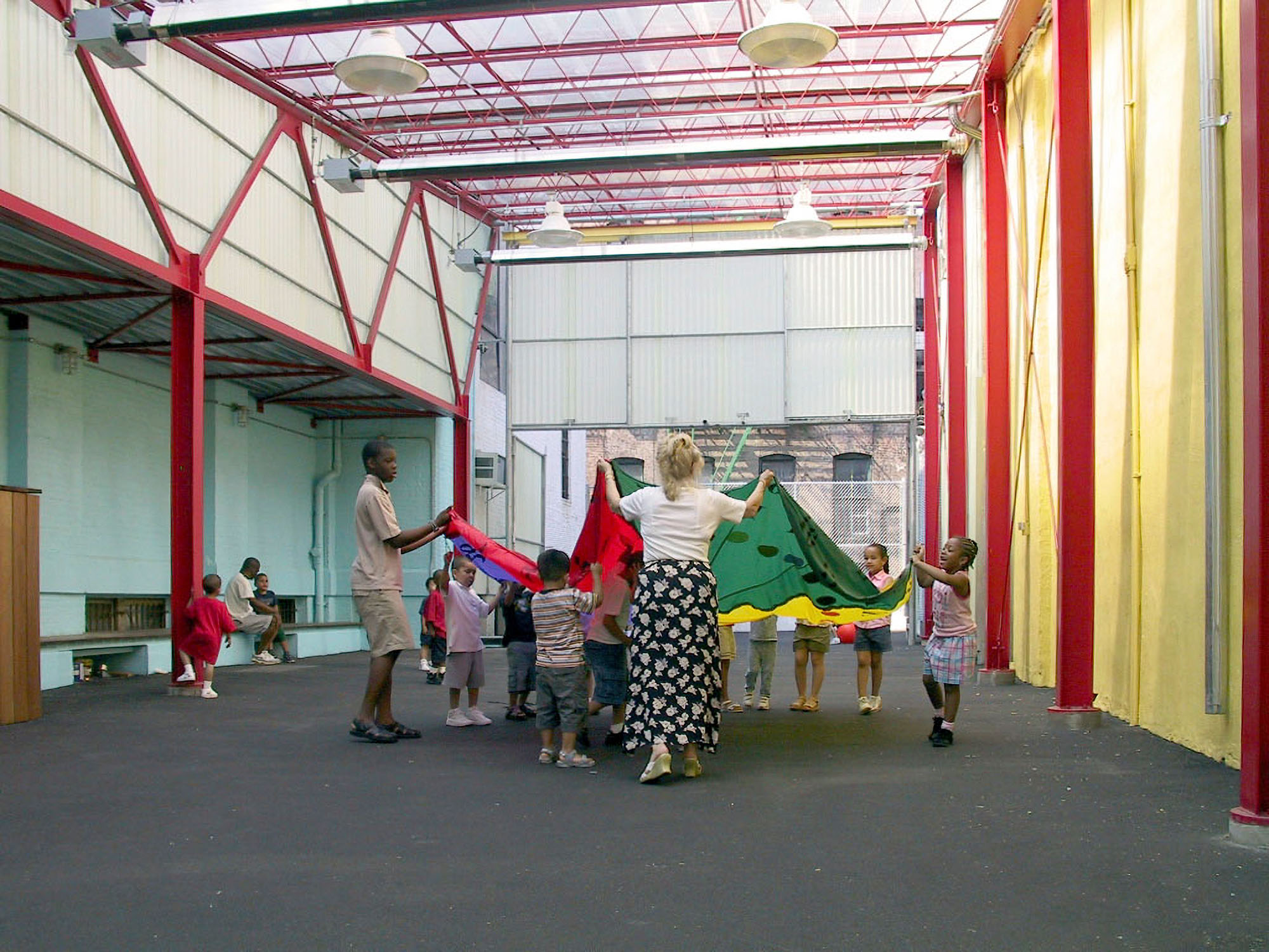 a photograph of children and teachers playing inside a playspace