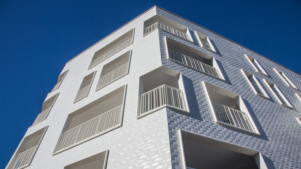 White, ceramic tile-clad building with balconies.