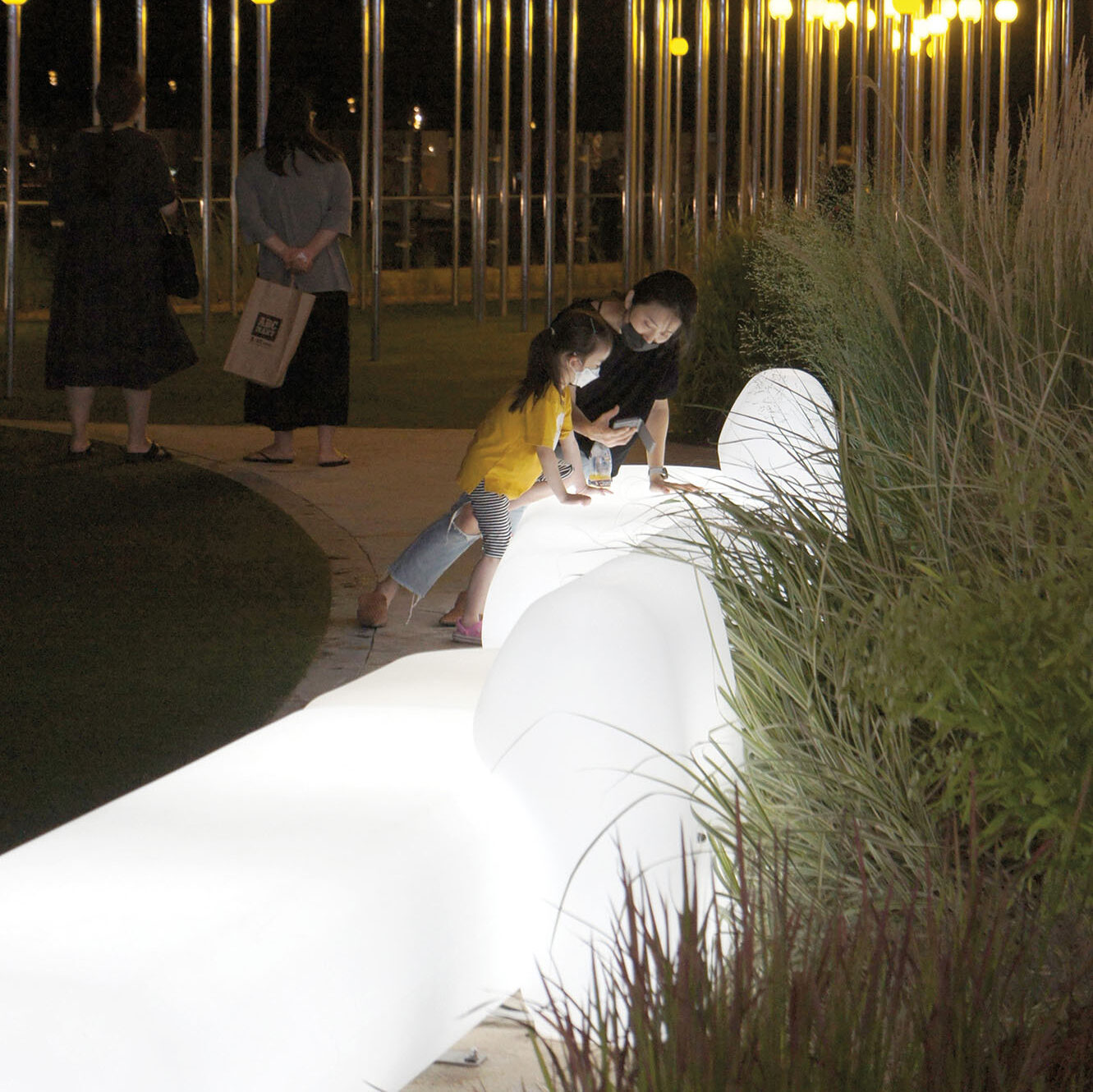An image of two people engaging with an illuminated plastic bench