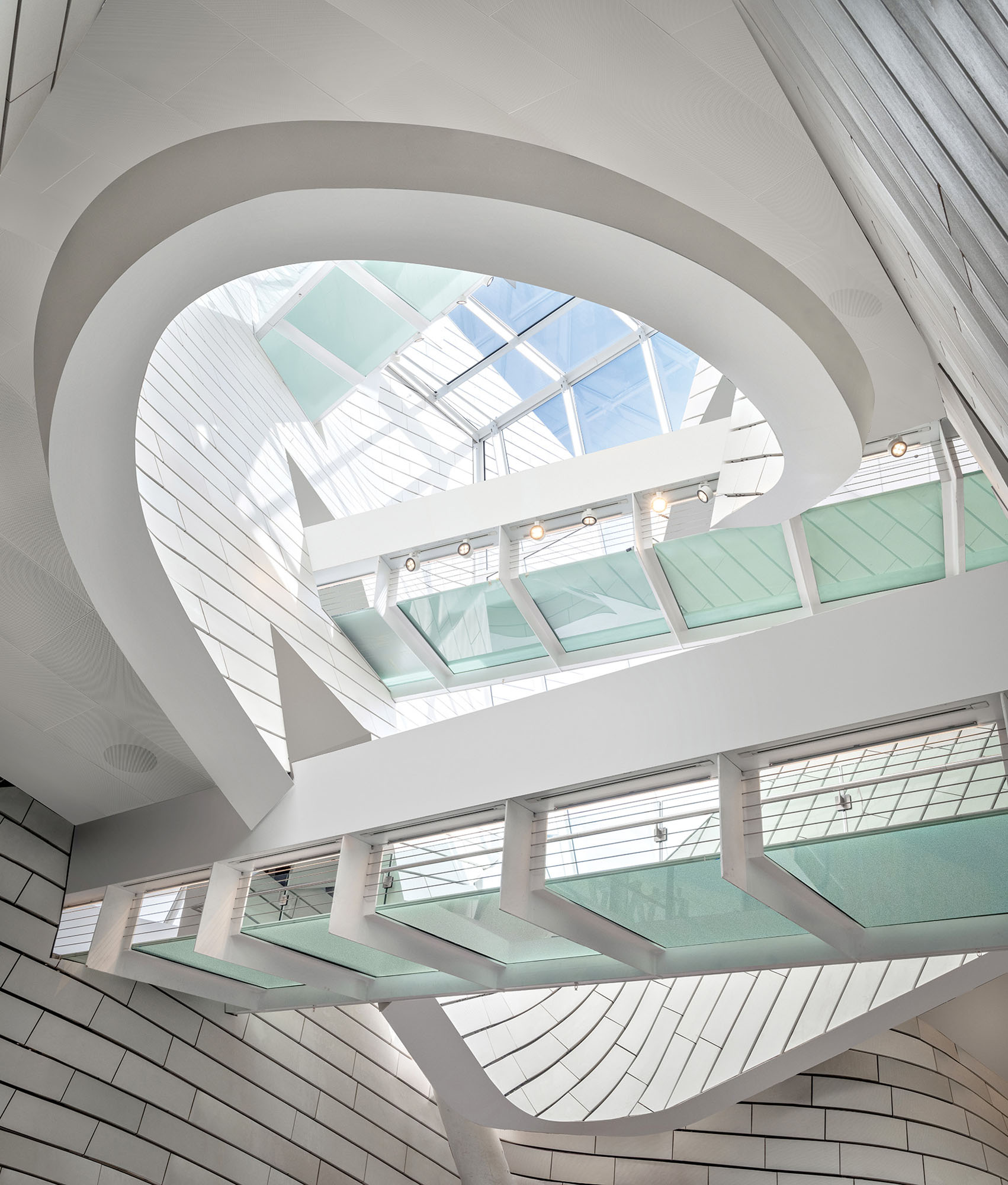 An interior photograph of the museum's atrium clad in tiles with a catwalk across it.