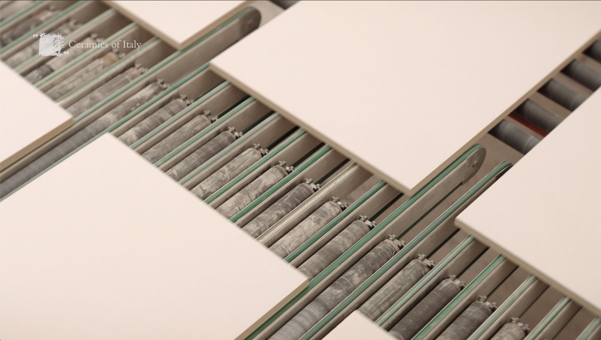 Unfinished rectangular tiles on a conveyor belt.