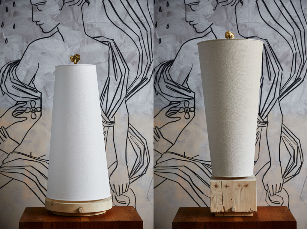 image of two table lamps sitting on top of a table in front of figural wallpaper