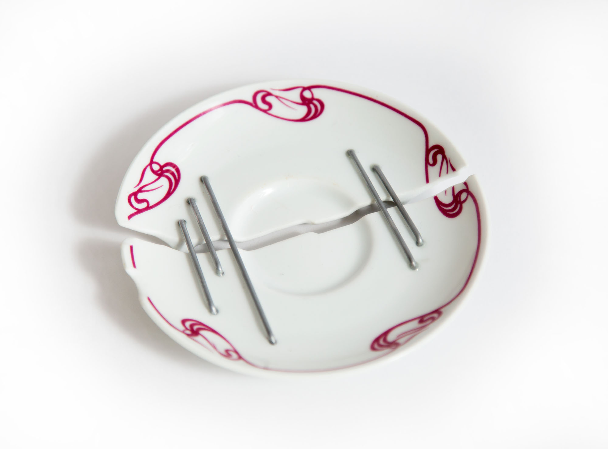 an image of a porcelain saucer stapled together 