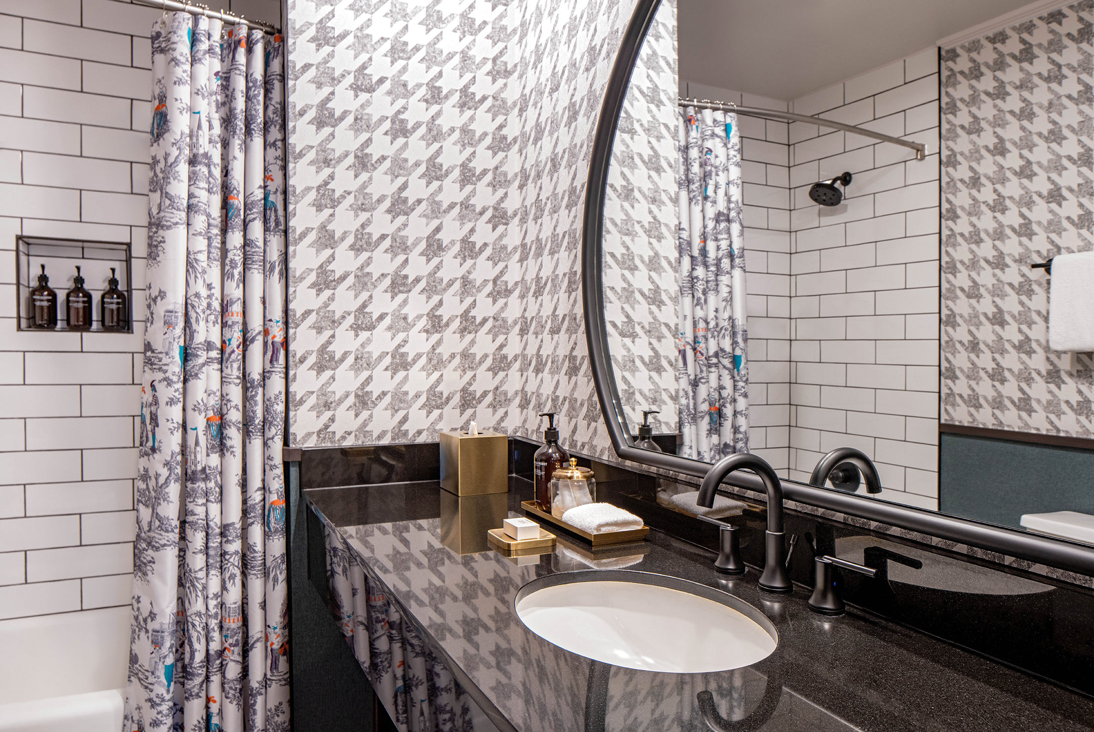 Interior image of a bathroom with houndstooth wallpaper and black countertops