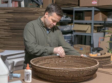 a man building a craft object out of cardboard